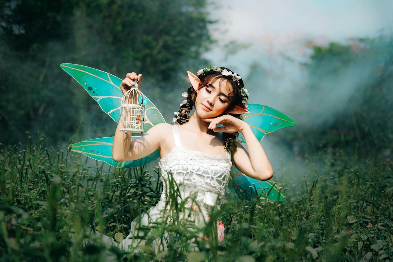 woman in white dress wearing green fairy wings