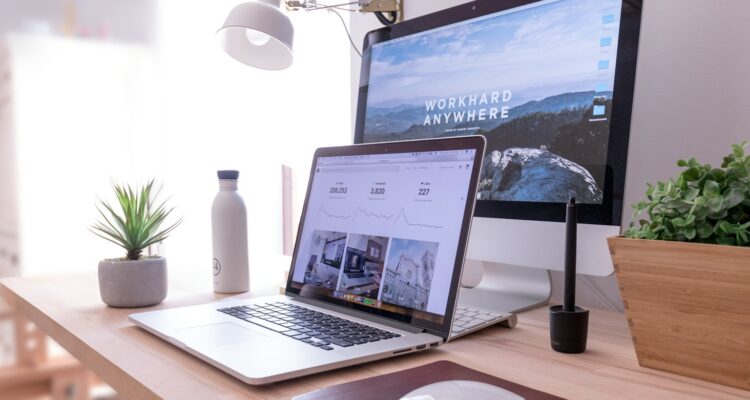 MacBook Pro on table beside white iMac and Magic Mouse