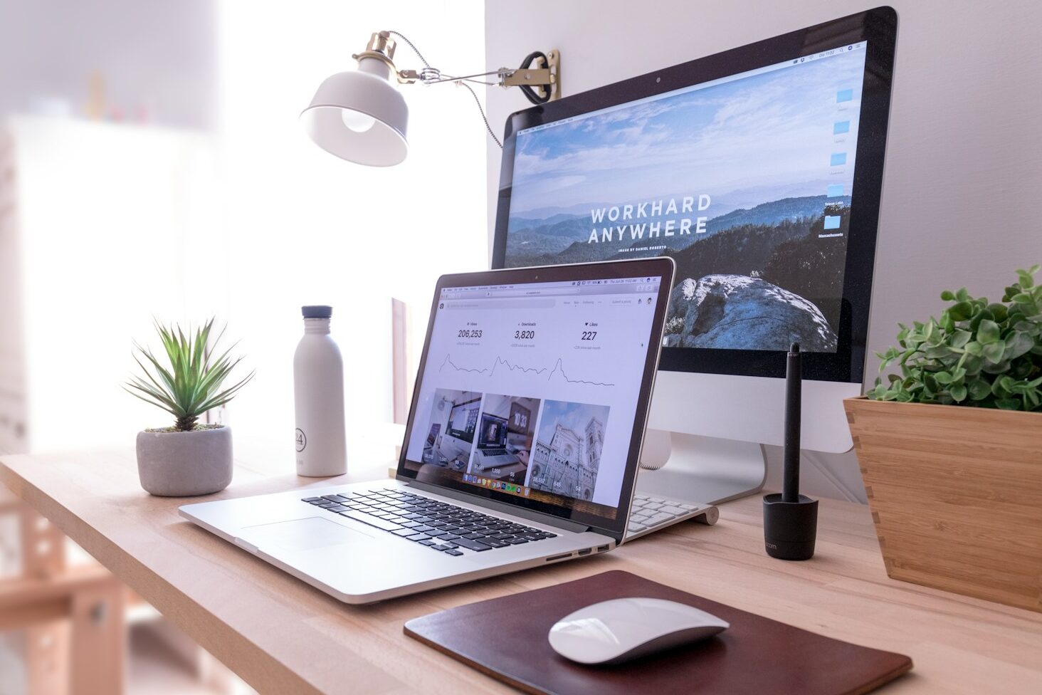 MacBook Pro on table beside white iMac and Magic Mouse