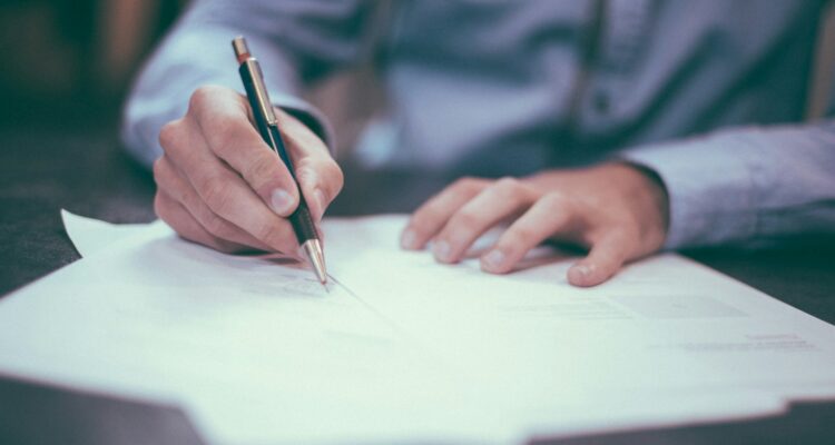 man writing on paper