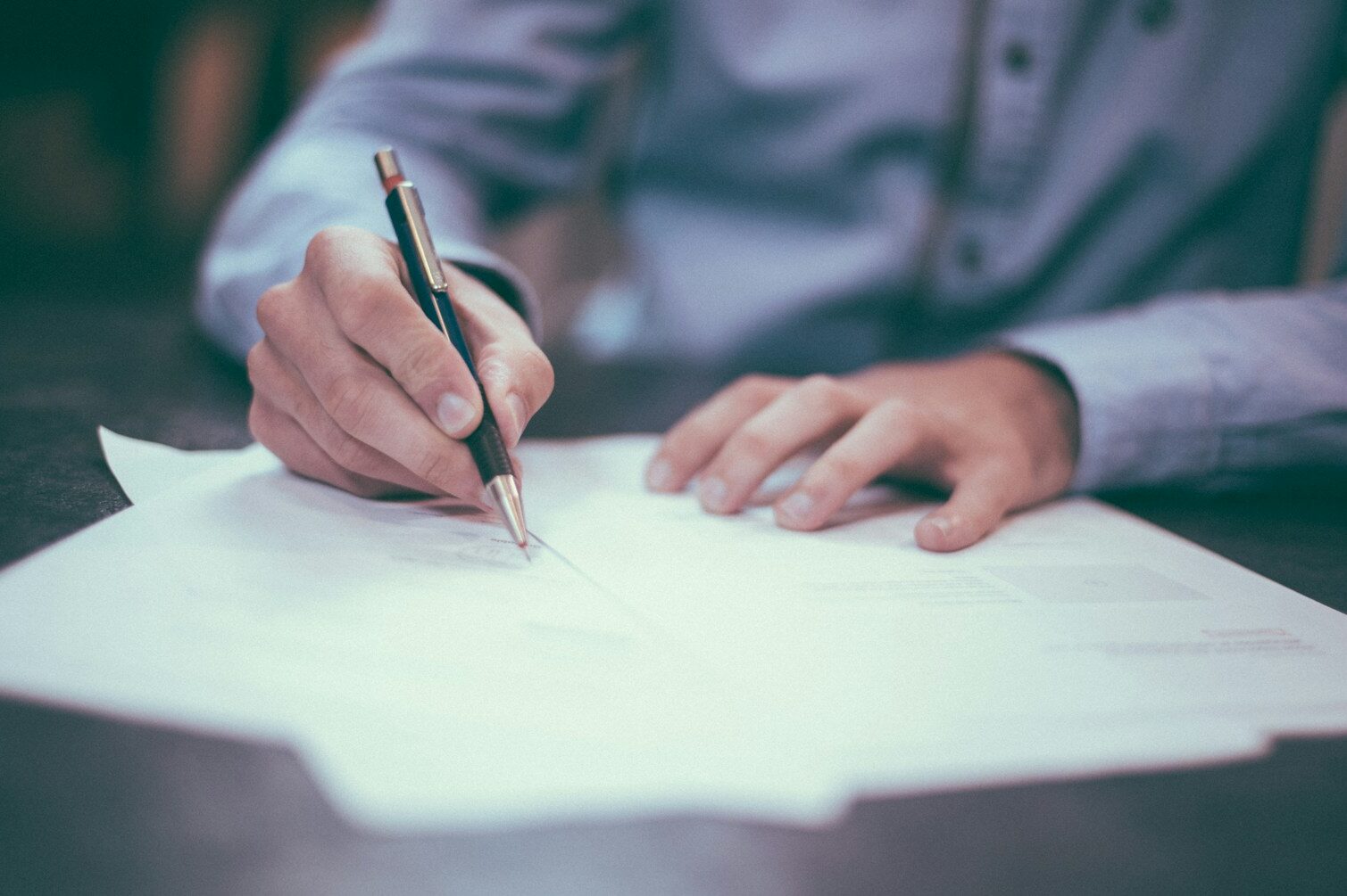 man writing on paper