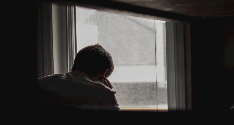 man looking outside by window